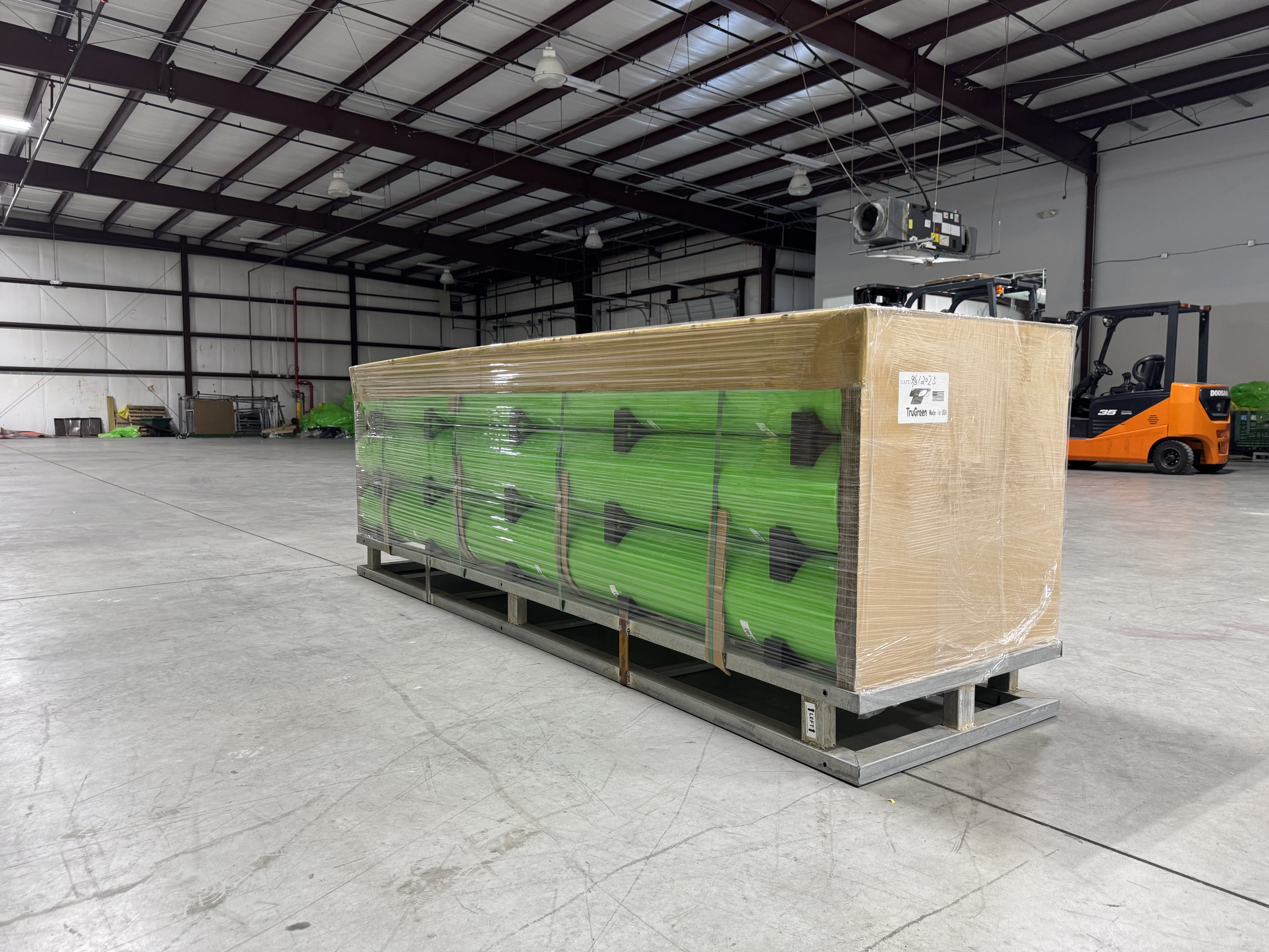 TRU·GREEN cotton bale wraps on metal pallet, forklift in background